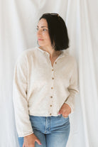 Model wearing button up cardigan in color oat. This cardigan is easy to wear open and layered over a variety of tanks and shirts or you can wear it buttoned up as a top.