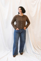 Chocolate brown rib knit cardigan for women featuring delicate ruffle trim, textured ribbed fabric, and a feminine design for elevated fall and winter styling.
