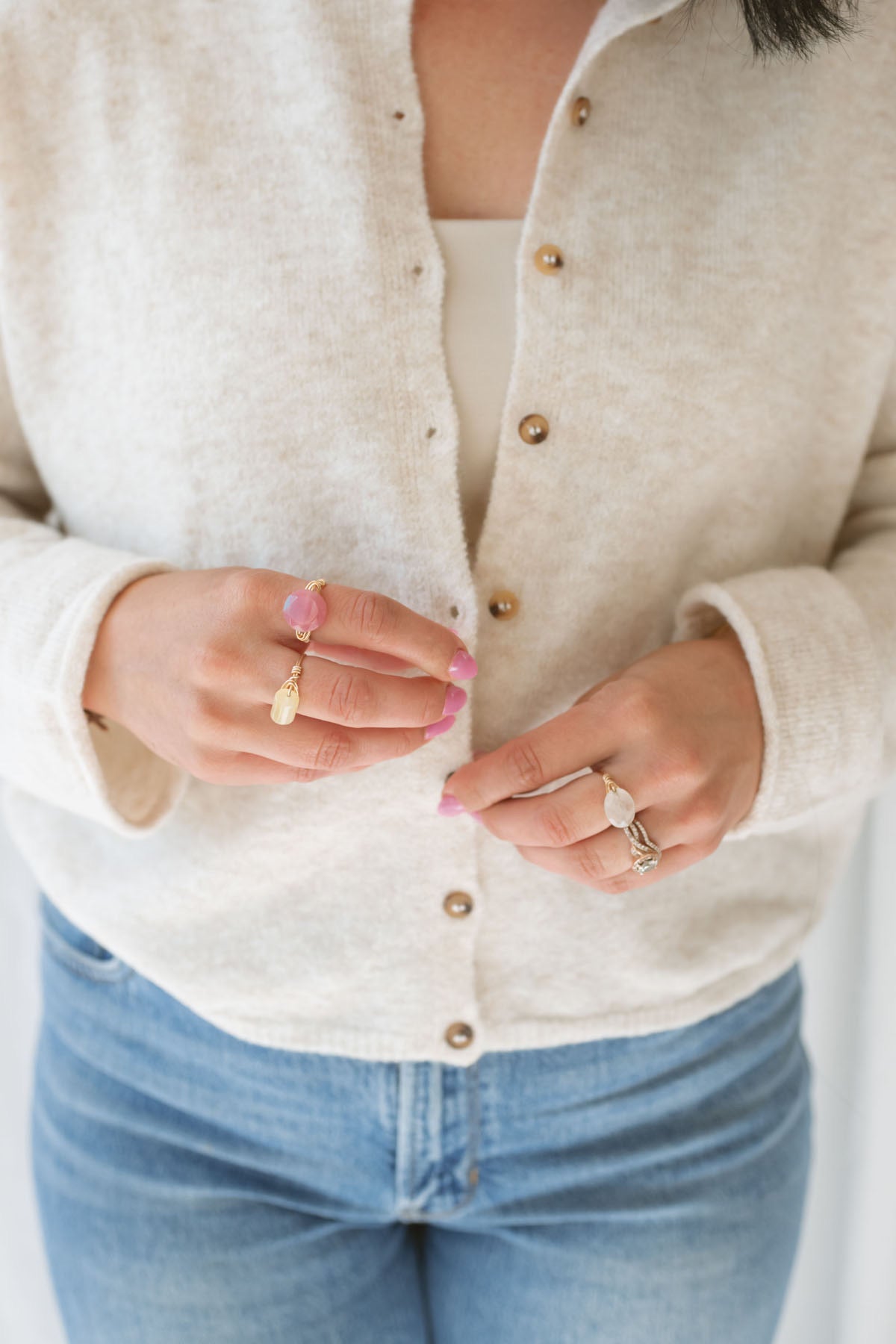 Close up view of model wearing button up cardigan in color oat. This cardigan is easy to wear open and layered over a variety of tanks and shirts or you can wear it buttoned up as a top.