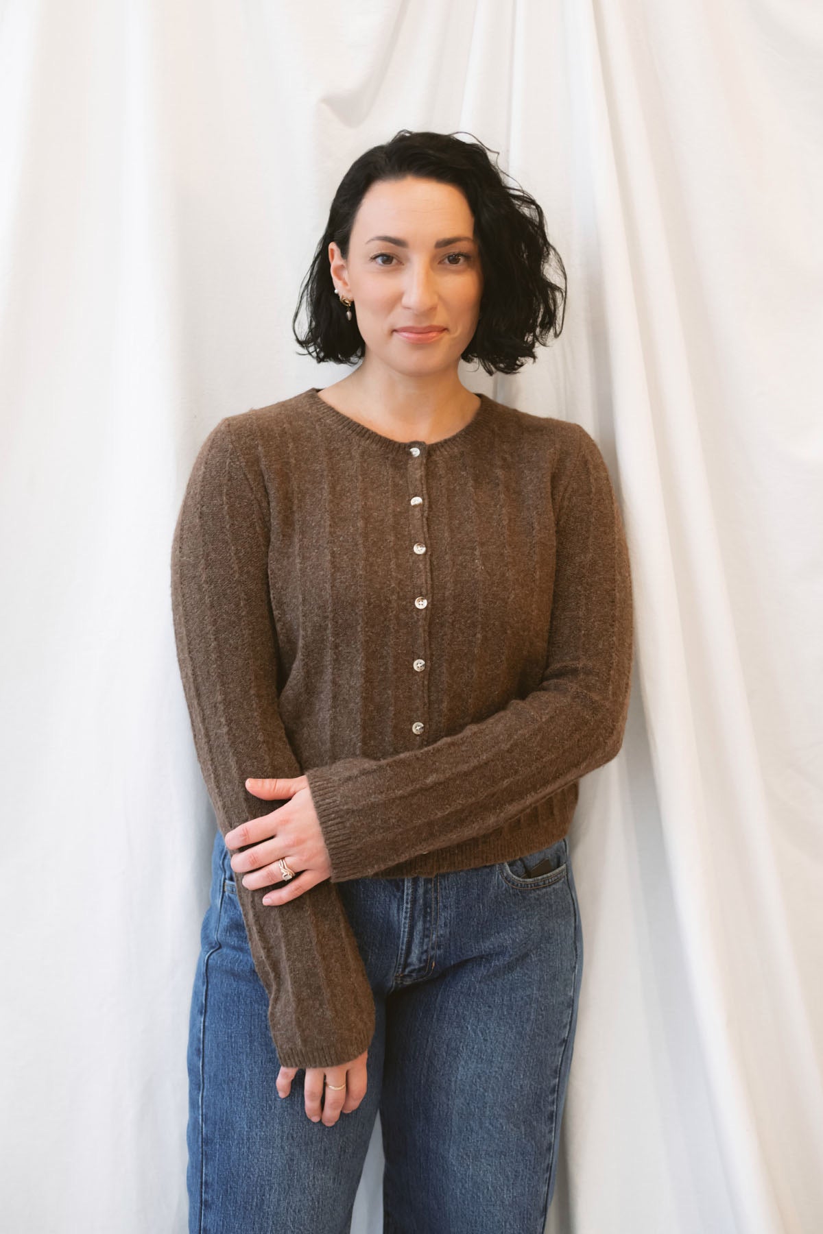 Chocolate brown rib knit cardigan for women featuring delicate ruffle trim, textured ribbed fabric, and a feminine design for elevated fall and winter styling.