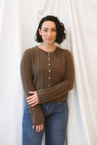 Chocolate brown rib knit cardigan for women featuring delicate ruffle trim, textured ribbed fabric, and a feminine design for elevated fall and winter styling.