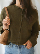 Model wearing full button up cardigan in olive. Cardigan is a great versatile option, because you can wear it fully buttoned up as a sweater or unbuttoned as a cardigan. 