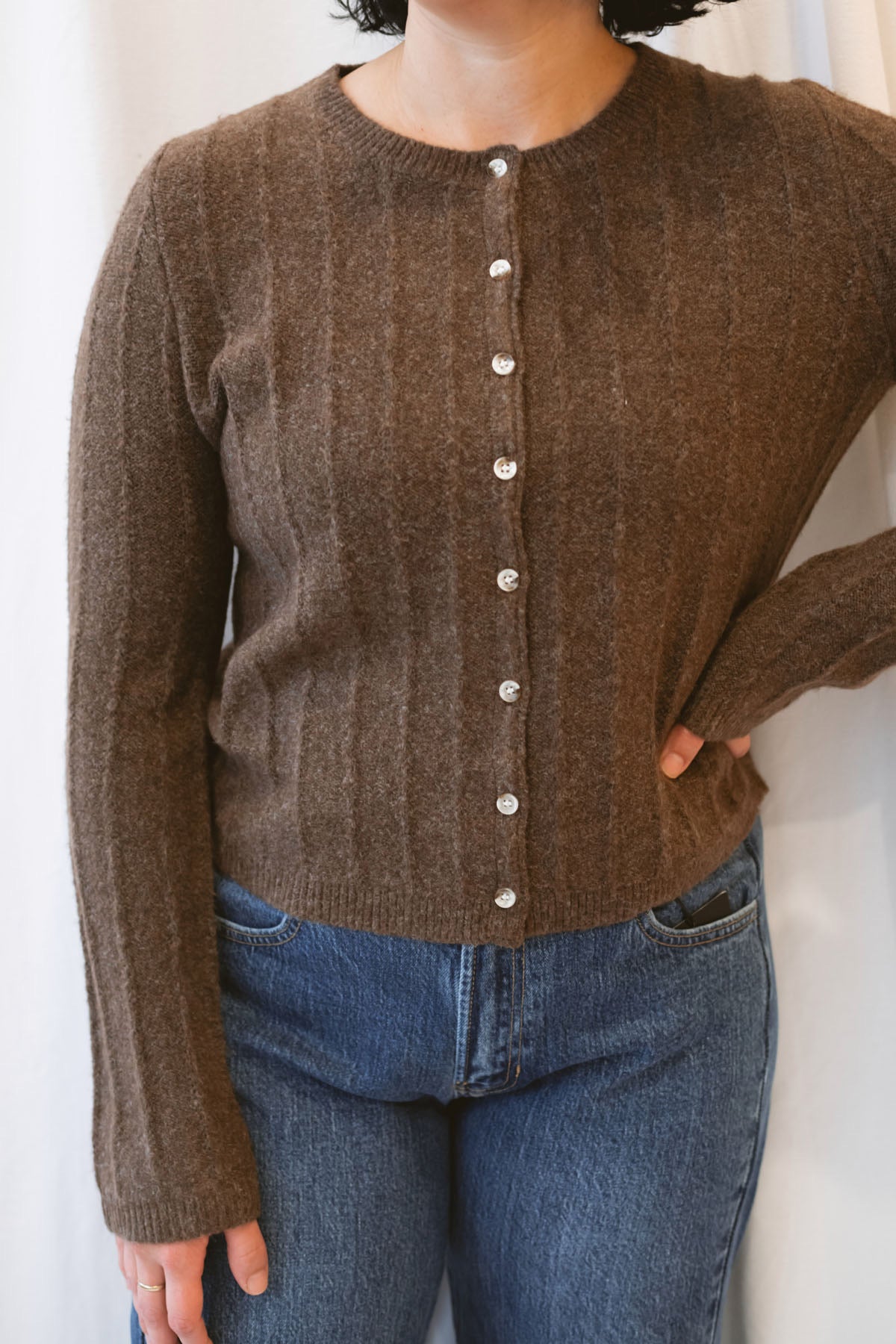 Chocolate brown rib knit cardigan for women featuring delicate ruffle trim, textured ribbed fabric, and a feminine design for elevated fall and winter styling.