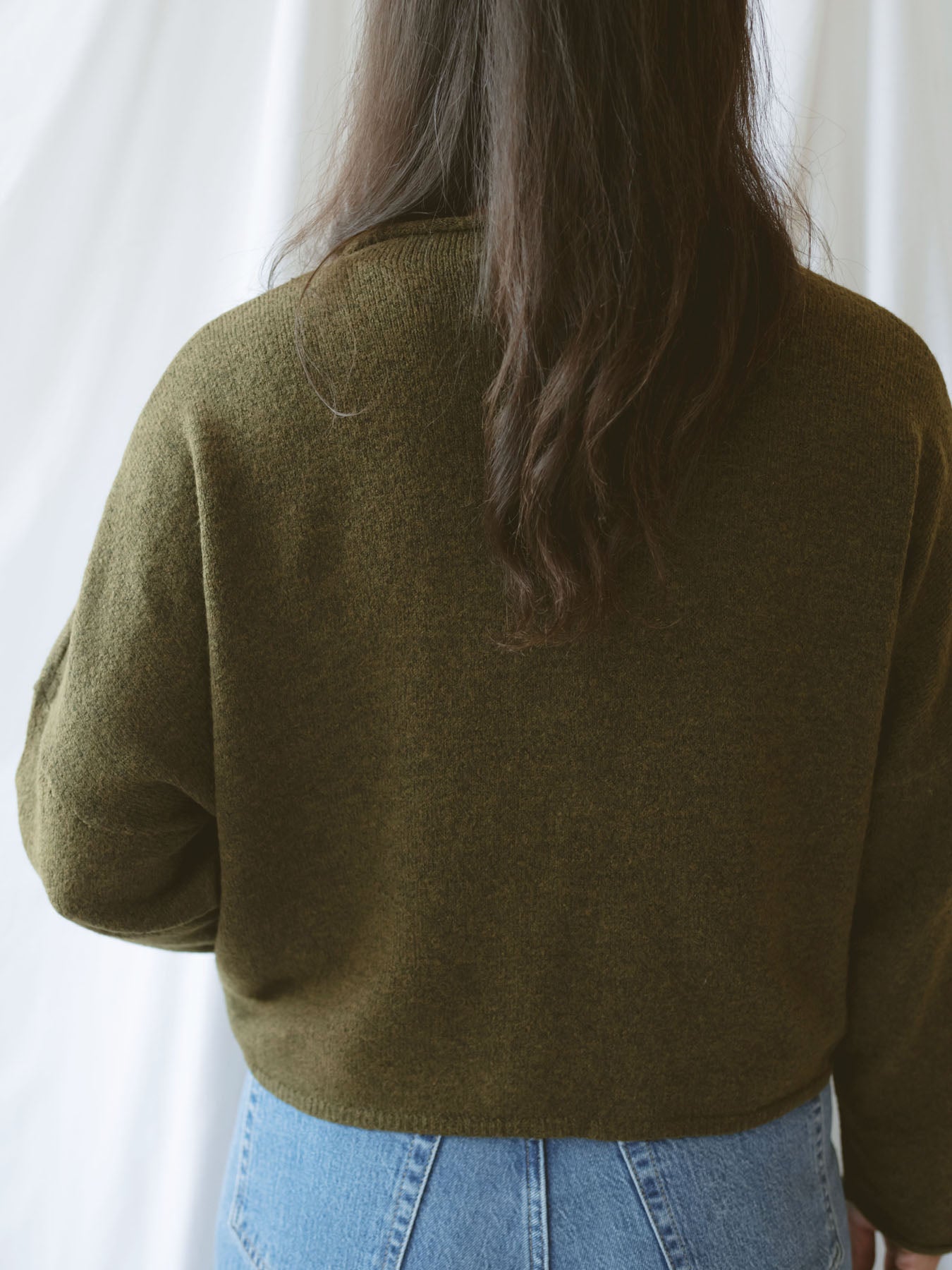 Model wearing full button up cardigan in olive. Cardigan is a great versatile option, because you can wear it fully buttoned up as a sweater or unbuttoned as a cardigan.