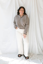 Close up view of model wearing the stripe drop shoulder long sleeve cardigan. This cardigan layers well over many tanks and shirts or you can wear it fully buttoned up as a top. Easy to transition form season to season. Model has cardigan styled as a shirt and paired with a pair of cream denim pants. 