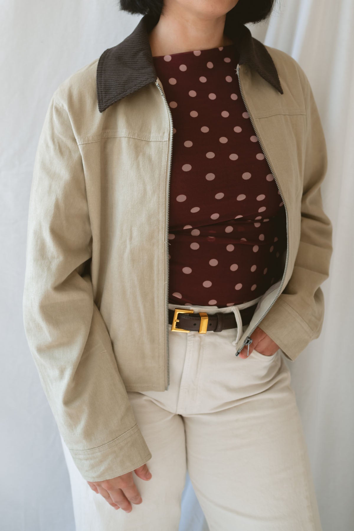 Model wearing the contrast corduroy collar zip up bomber jacket over the rynlee polka dot mesh tank in burgundy. The jacket is a great lightweight layer for cooler months. 