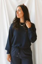 Model wearing textured exposed seam long sleeve top in color Navy. A great basic to dress up or down with a variety of pant styles. Model styled with our checkered drawstring waist pants in navy for a beautiful Monochromatic color combination and comfortable feel.