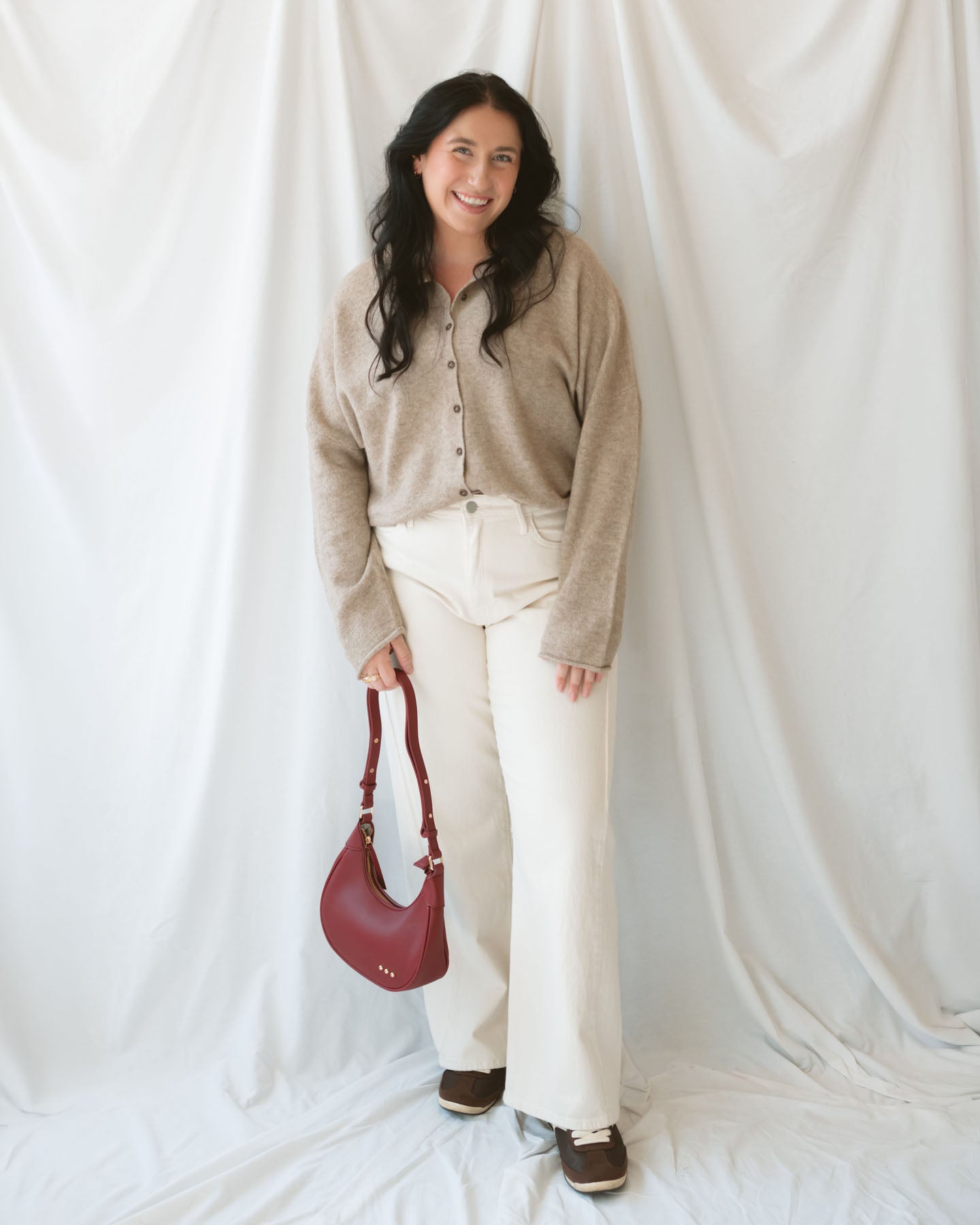 Model wearing full button cardigan in light mocha. Cardigan is a great versatile option because you can wear it fully buttoned as a sweater or open and layered as a cardigan. 