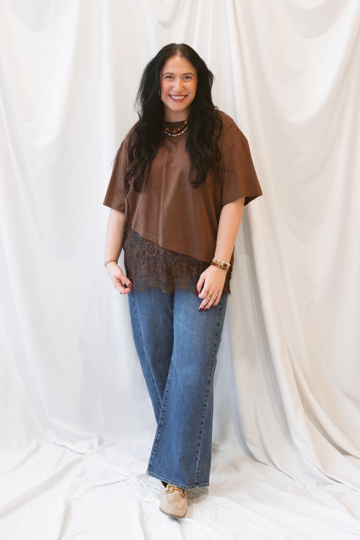 Chocolate brown women's t-shirt featuring delicate floral lace trim and an asymmetrical silhouette for a feminine, elevated everyday look.