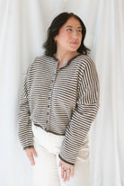 Close up view of model wearing the stripe drop shoulder long sleeve cardigan. This cardigan layers well over many tanks and shirts or you can wear it fully buttoned up as a top. Easy to transition form season to season. 