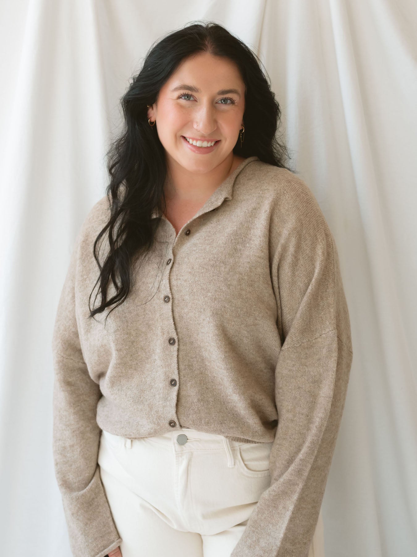 Model wearing full button cardigan in light mocha. Cardigan is a great versatile option because you can wear it fully buttoned as a sweater or open and layered as a cardigan. 