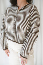 Close up view of model wearing the stripe drop shoulder long sleeve cardigan. This cardigan layers well over many tanks and shirts or you can wear it fully buttoned up as a top. Easy to transition form season to season. 