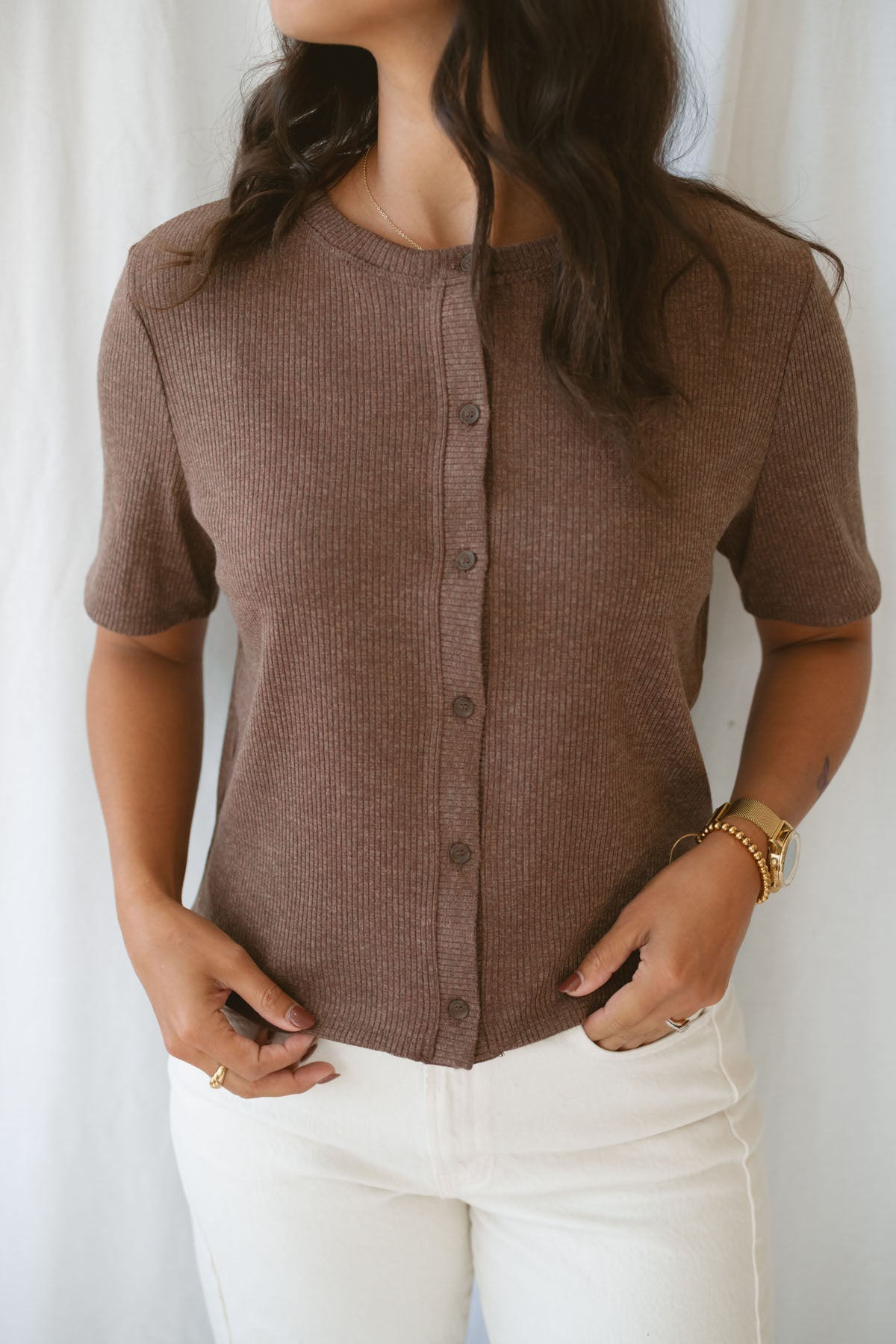 Model is wearing the ribbed short sleeve cardigan in brown. Model has it paired with an off white denim pant for a cassic and timeless look.
