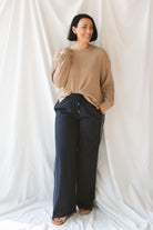 Model wearing textured exposed seam long sleeve top in color khaki. A great basic to dress up or down with a variety of pant styles. Model styled with our checkered drawstring waist pants in navy for a beautiful color combination and comfortable feel.