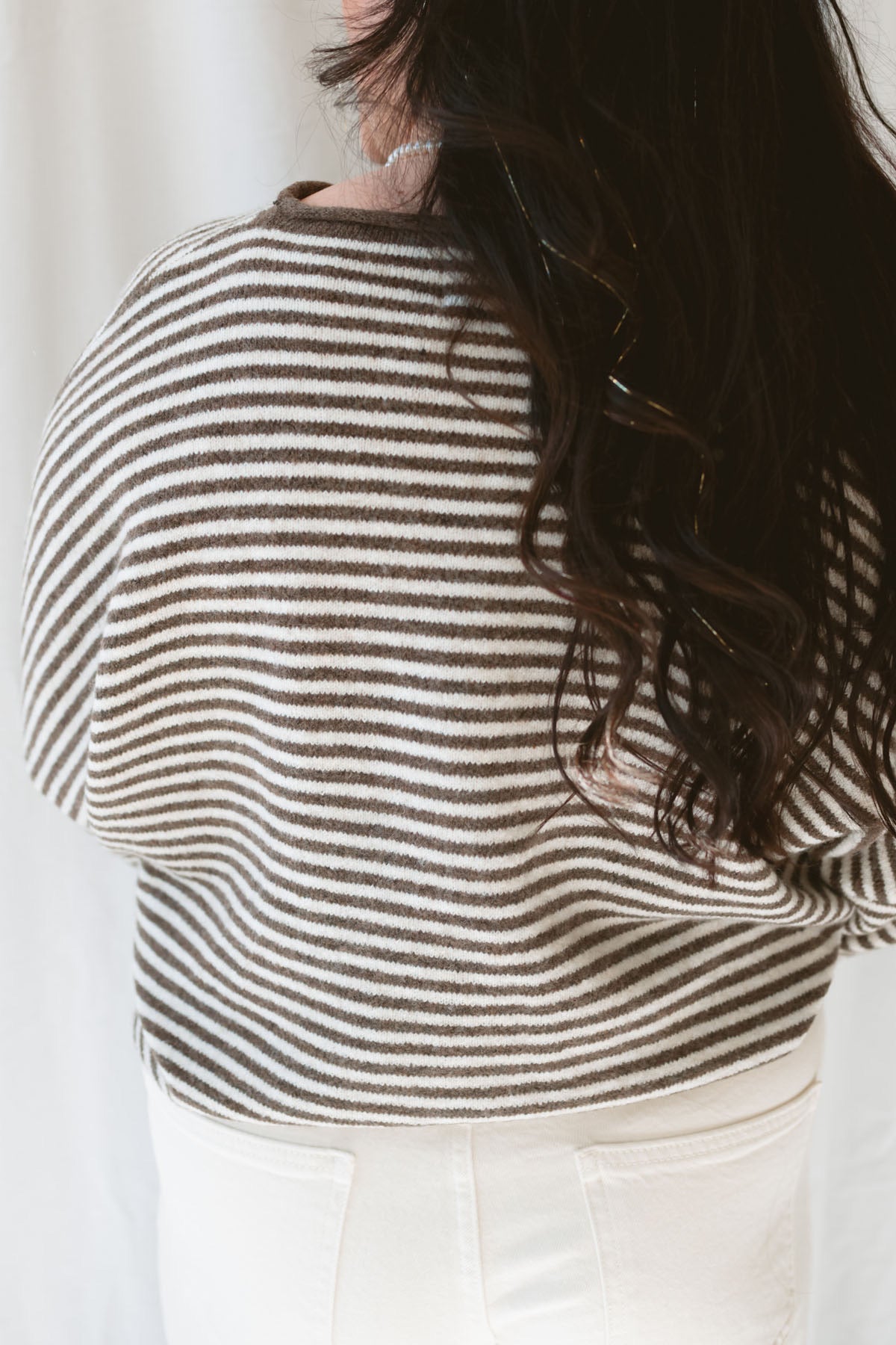 Back view of model wearing the stripe drop shoulder long sleeve cardigan. This cardigan layers well over many tanks and shirts or you can wear it fully buttoned up as a top. Easy to transition form season to season. 