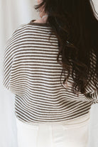 Back view of model wearing the stripe drop shoulder long sleeve cardigan. This cardigan layers well over many tanks and shirts or you can wear it fully buttoned up as a top. Easy to transition form season to season. 