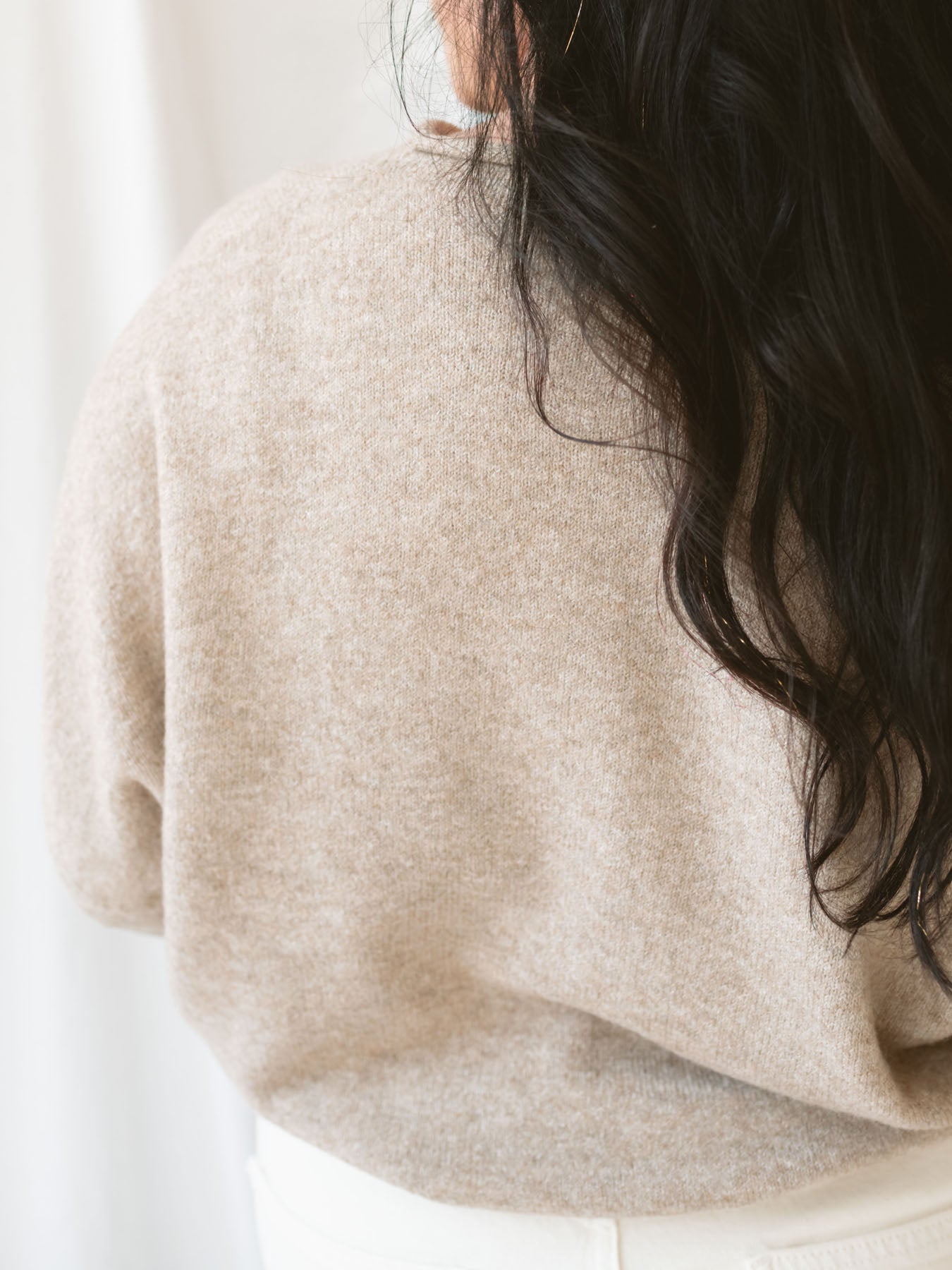 Model wearing full button cardigan in light mocha. Cardigan is a great versatile option because you can wear it fully buttoned as a sweater or open and layered as a cardigan. 
