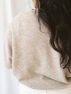 Model wearing full button cardigan in light mocha. Cardigan is a great versatile option because you can wear it fully buttoned as a sweater or open and layered as a cardigan. 