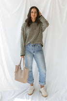 Model wearing the olive striped long sleeve henley sweater. 