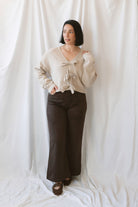 Kayla light taupe knit sweater with a reversible ribbon bow detail, styled with the bow in front.