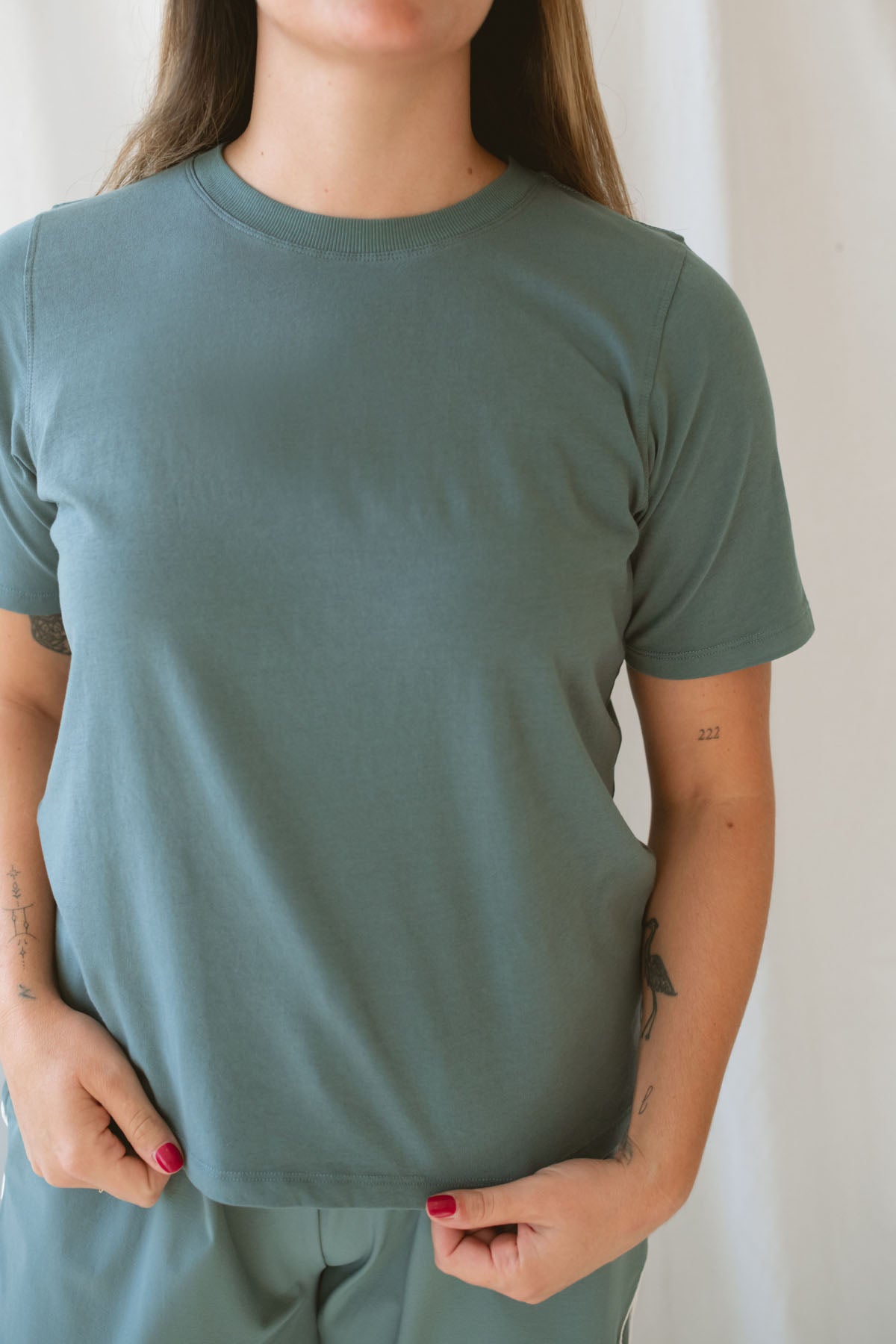 Model is wearing a classic boxy fit tee in the color eucalyptus green. 