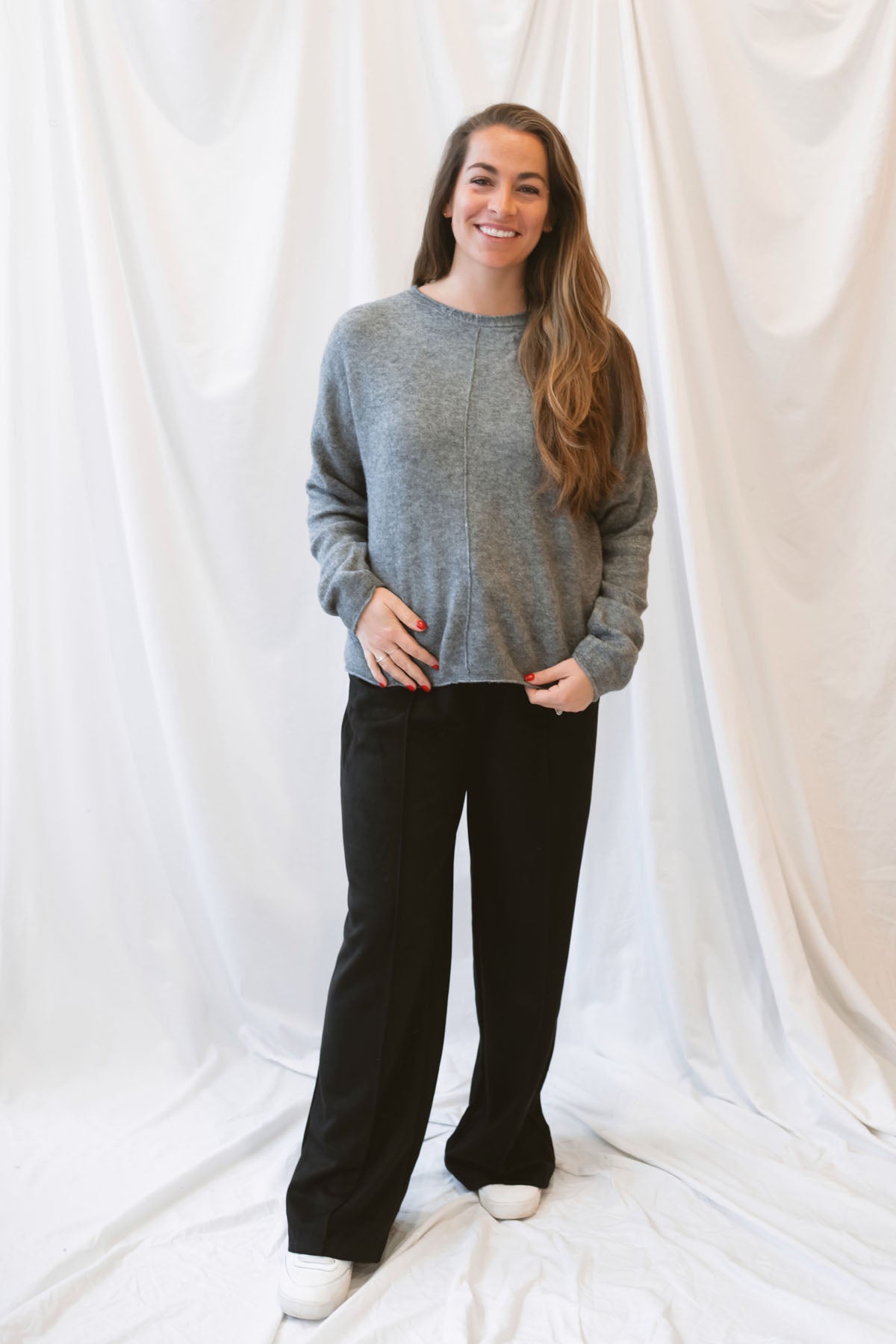 Grey knit sweater for women featuring a softly rolled neckline, center seam detailing, and a classic relaxed silhouette for everyday fall and winter styling.