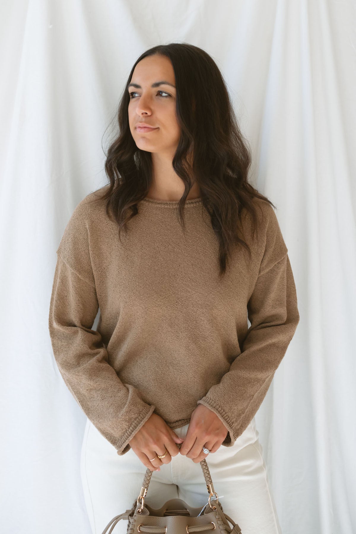 Model wearing long sleeve raw edge knit sweater. Paired with shorts during the summer or pants heading into the cooler seasons makes this a great staple season after season. 