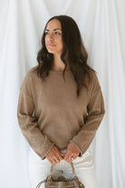 Model wearing long sleeve raw edge knit sweater. Paired with shorts during the summer or pants heading into the cooler seasons makes this a great staple season after season. 