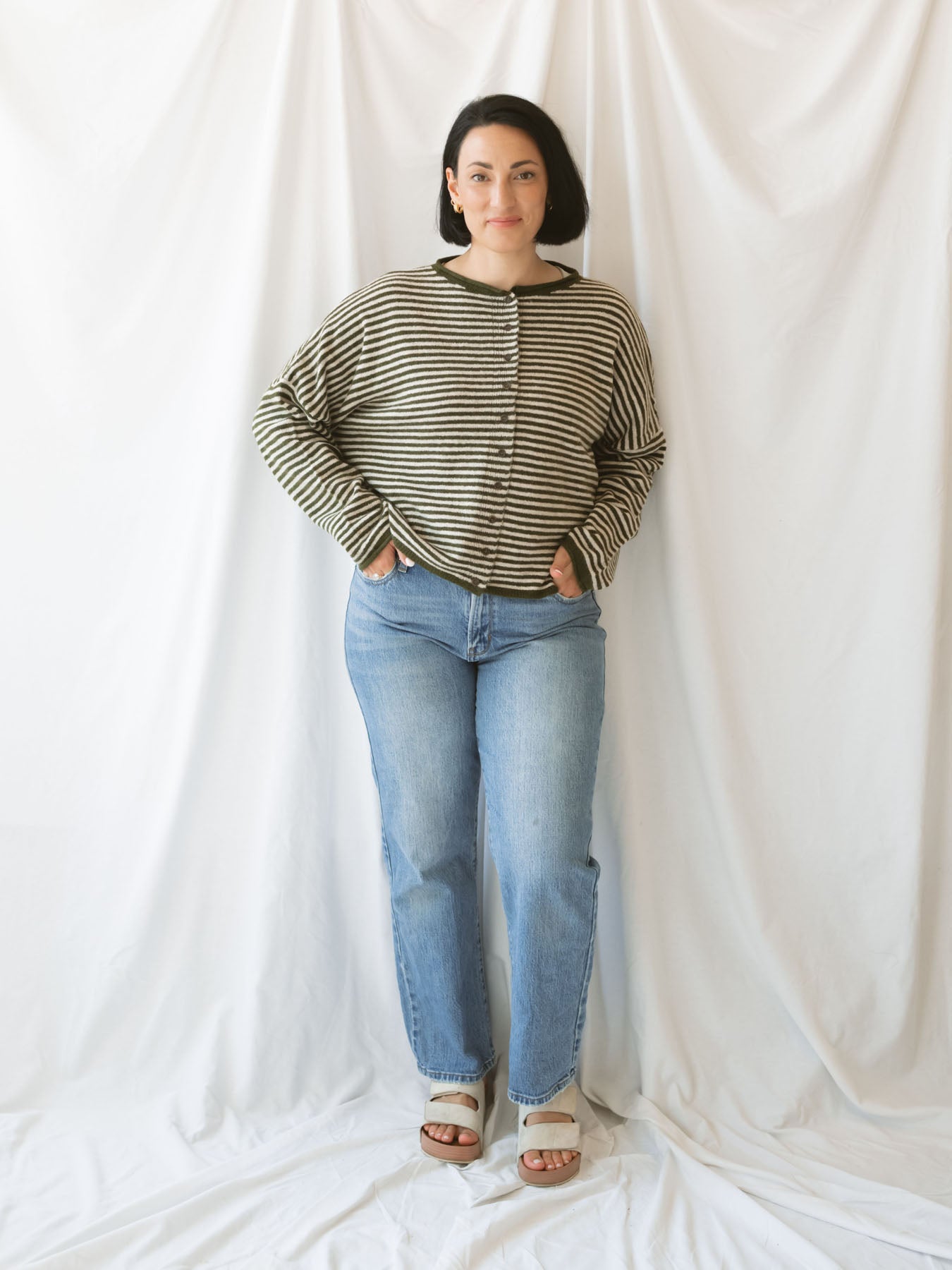 Model wearing striped full button cardigan. Styled fully buttoned up with a pair of classic denim. 