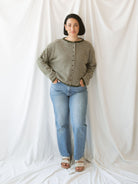 Model wearing striped full button cardigan. Styled fully buttoned up with a pair of classic denim. 