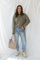 Model wearing the olive striped long sleeve henley sweater. 