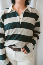 Model wearing rugby style top in green and grey. 