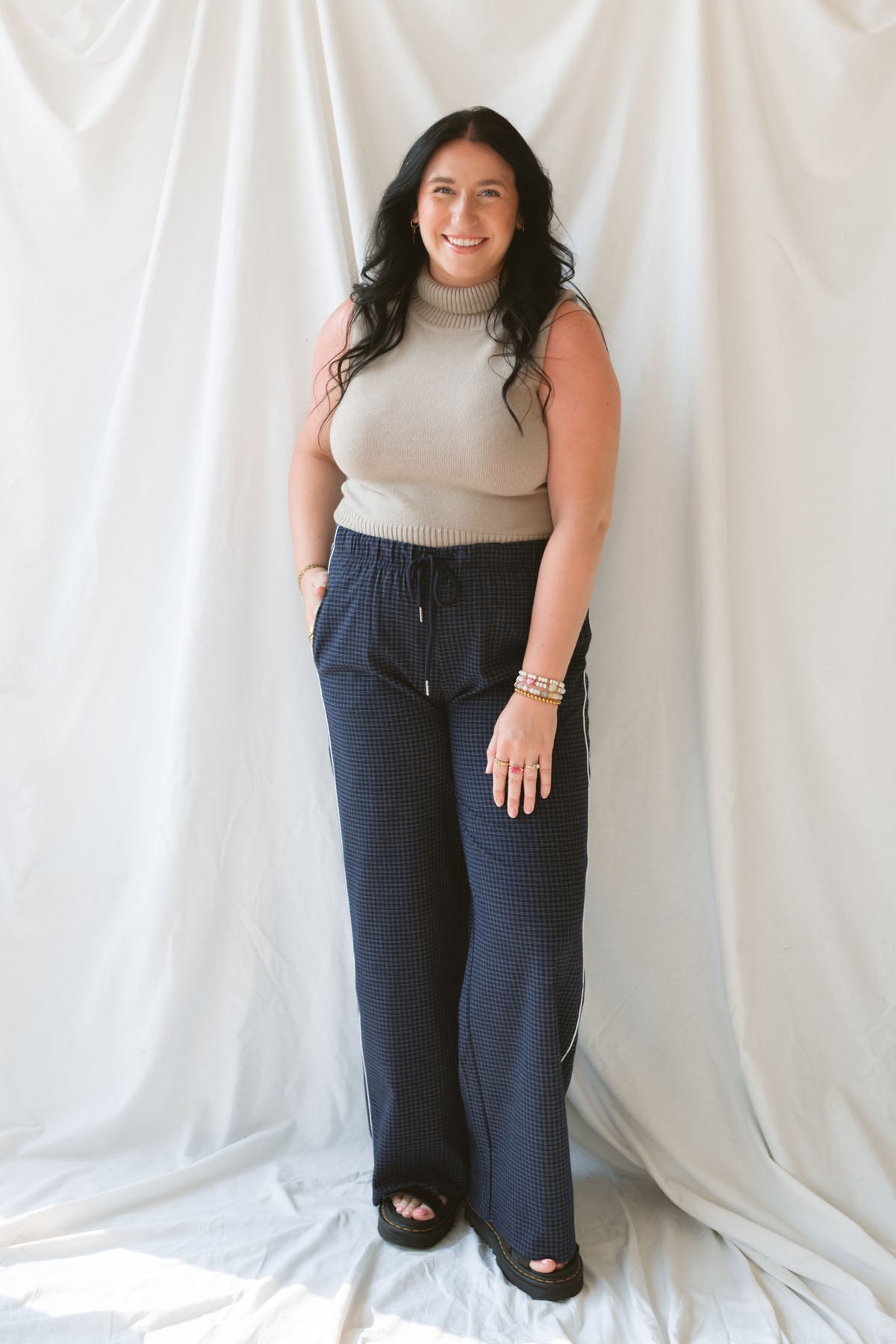 Model is wearing sleeveless knit turtleneck top styled with the Jude Check Woven Pants. Outfit is tailored and great for many occasions. 