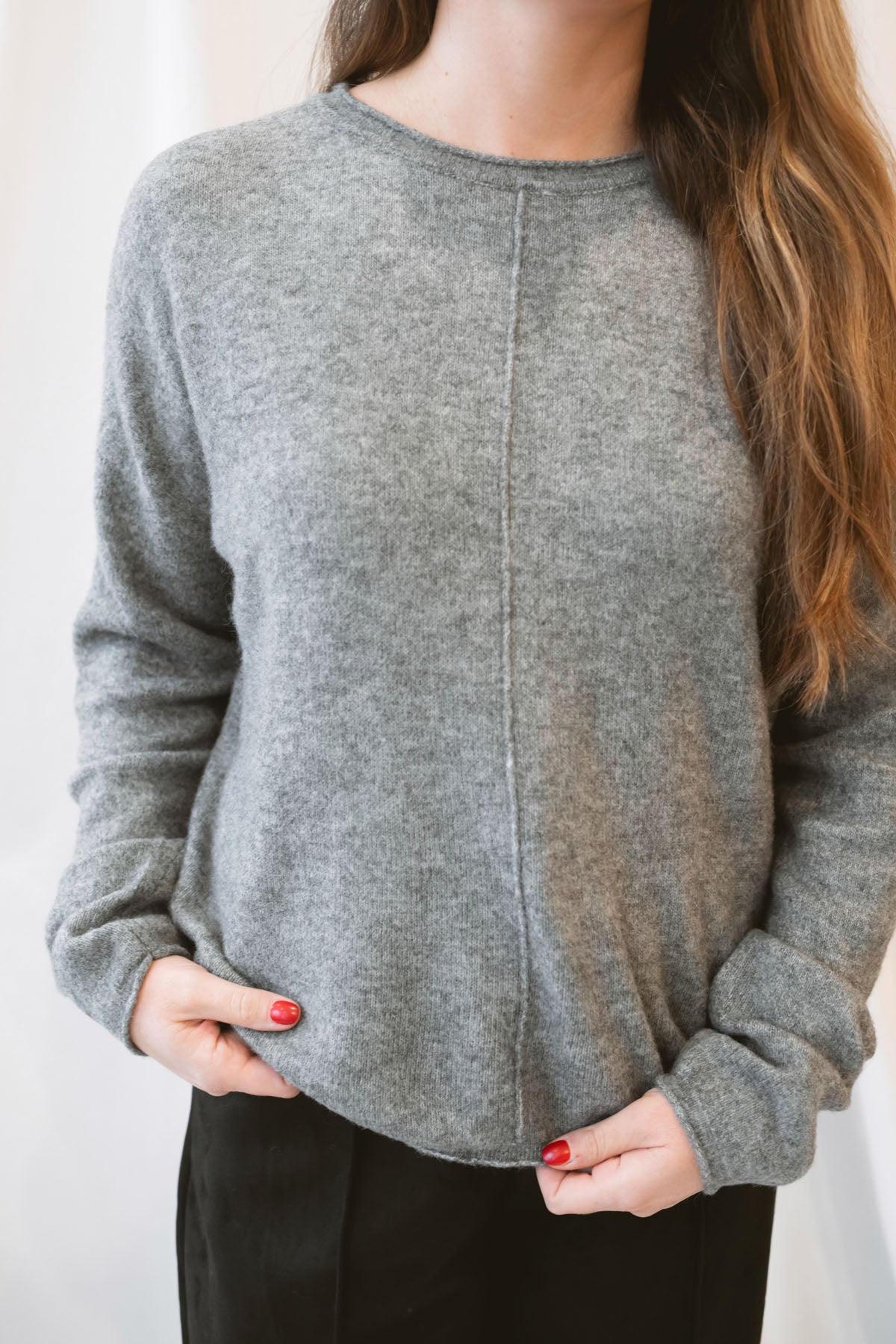 Grey knit sweater for women featuring a softly rolled neckline, center seam detailing, and a classic relaxed silhouette for everyday fall and winter styling.