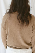 Back view of model wearing long sleeve raw edge knit sweater. Paired with shorts during the summer or pants heading into the cooler seasons makes this a great staple season after season. 