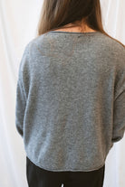 Grey knit sweater for women featuring a softly rolled neckline, center seam detailing, and a classic relaxed silhouette for everyday fall and winter styling.