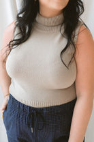 Close up view of model wearing sleeveless knit turtleneck top styled with the Jude Check Woven Pants. Outfit is tailored and great for many occasions. 