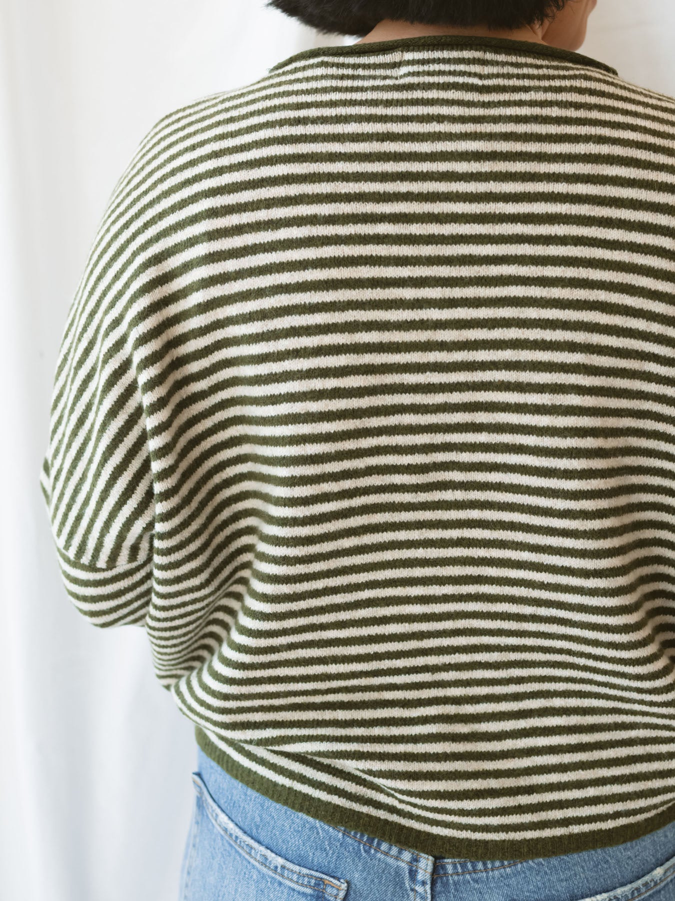 Model wearing striped full button cardigan. Styled fully buttoned up with a pair of classic denim. 
