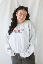 Model wearing the Teacher embroidered icons sweatshirt. 