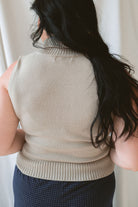 back view of model wearing sleeveless knit turtleneck top styled with the Jude Check Woven Pants. Outfit is tailored and great for many occasions. 