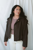 Model is wearing the suede bomber jacket in coffee brown. 