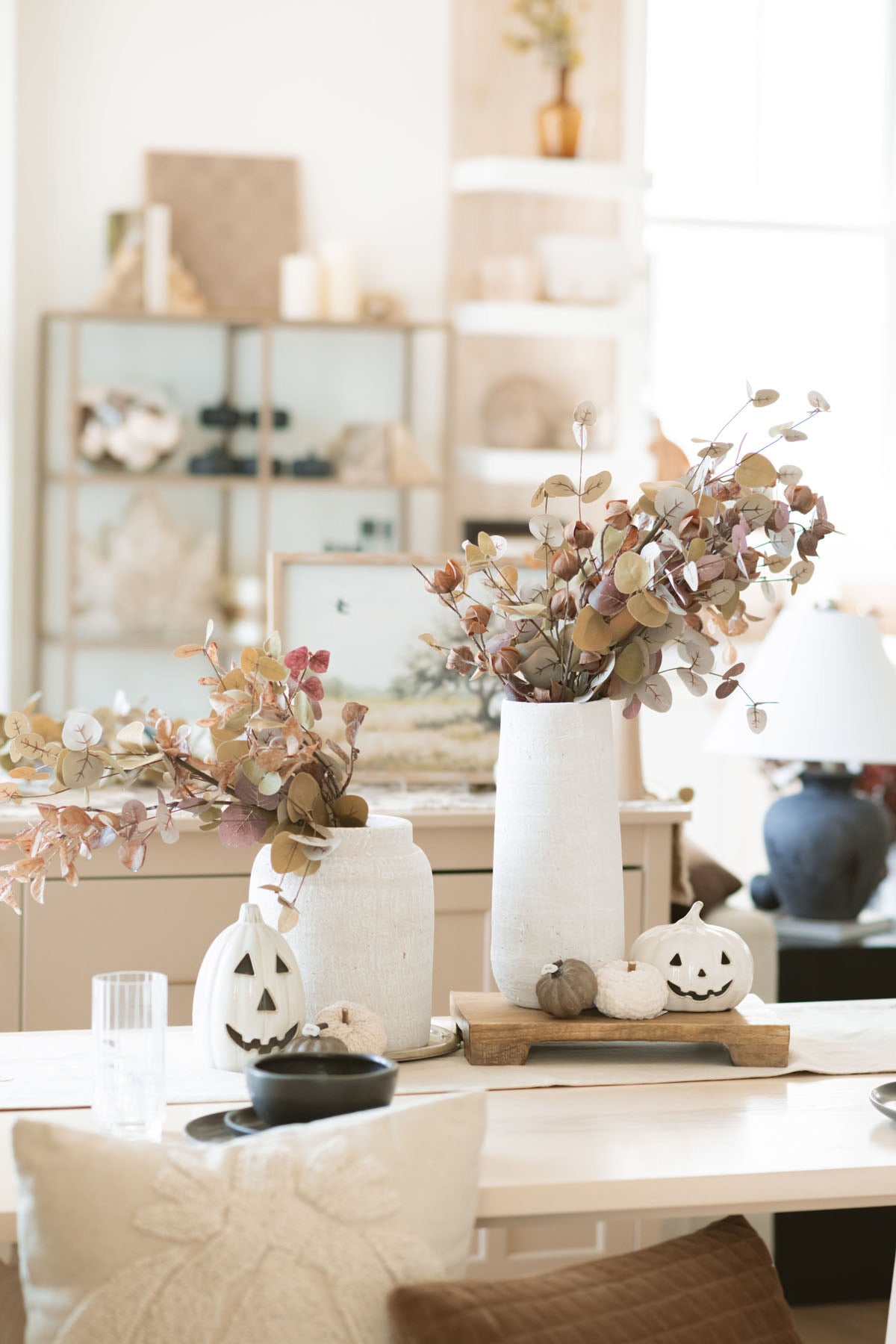 The tan two tone eucalyptus stem styled on the dinning room table in white vase. 