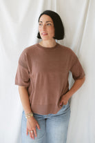 Model wearing the boxy fit short sleeve sweater in a rusty rose / sepia color. Model paired the top with jeans and a platform sandal. Wears well through seasons. 