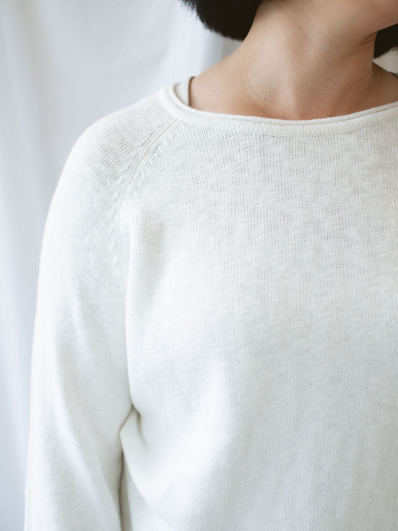 Model wearing slub pullover sweater in off white. 
