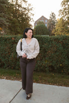 Kayla light taupe knit sweater with a reversible ribbon bow detail, styled with the bow in front.