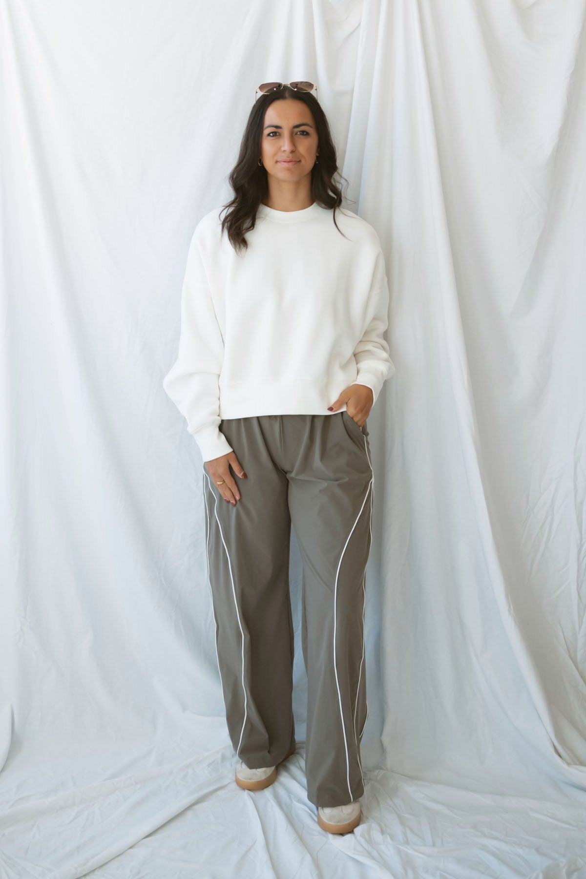 Model wearing the drawstring waist track pants in truffle. 