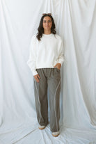 Model wearing the drawstring waist track pants in truffle. 