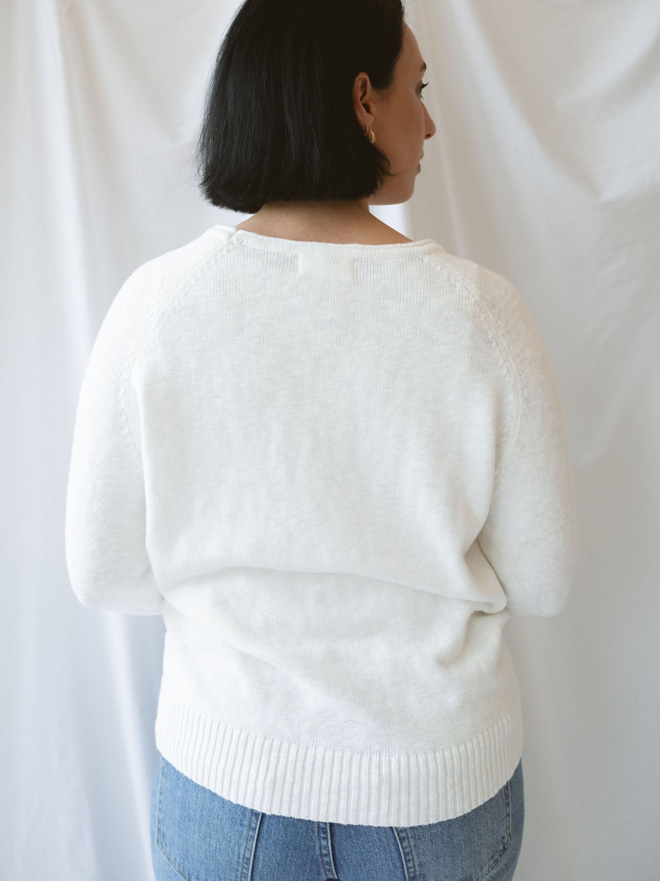 Model wearing slub pullover sweater in off white. 