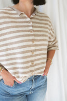 Model wearing stripe raw edge short sleeve button down. 