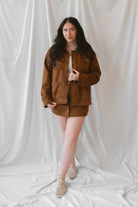 Ava Snap Front Suede Mini Skirt in cognac featuring a warm brown suede-style finish and snap-front detailing.